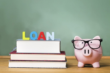 piggy bank wearing glasses next to books that have loan on them